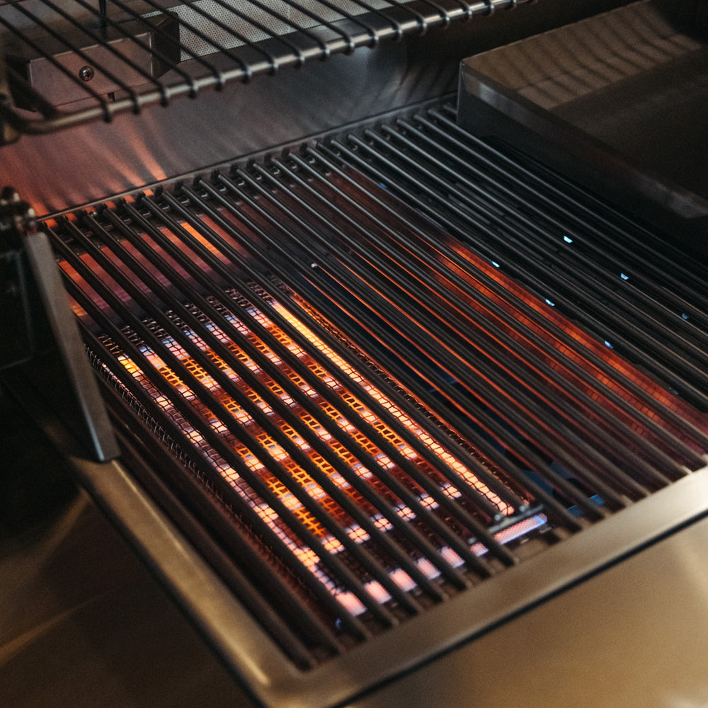 Glowing infrared burner beneath the cooking grates of the American Made Grills Estate gas grill